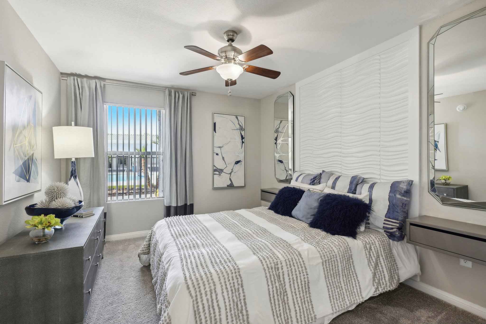 bedroom decorative wall with mirrors window showing view of pool at Millennium East