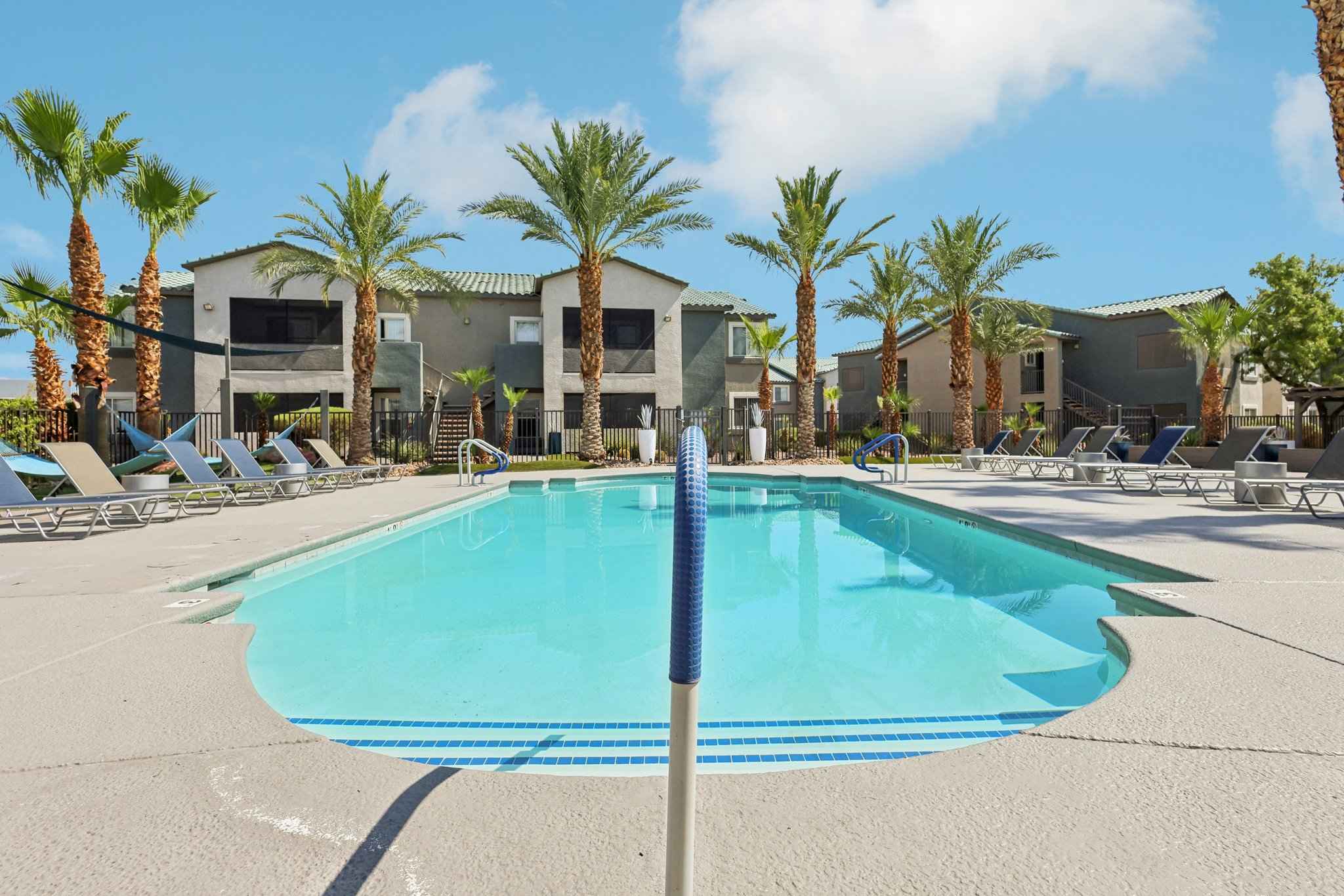 daytime view of the community pool and lounge chairs at Millennium East