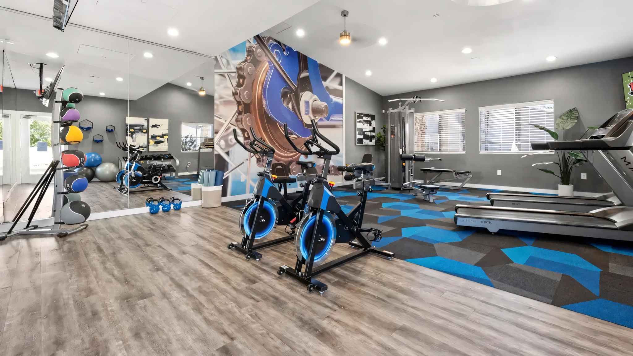 fitness center full view of cardio machines and weight machines with mirrors on the wall at Millennium East