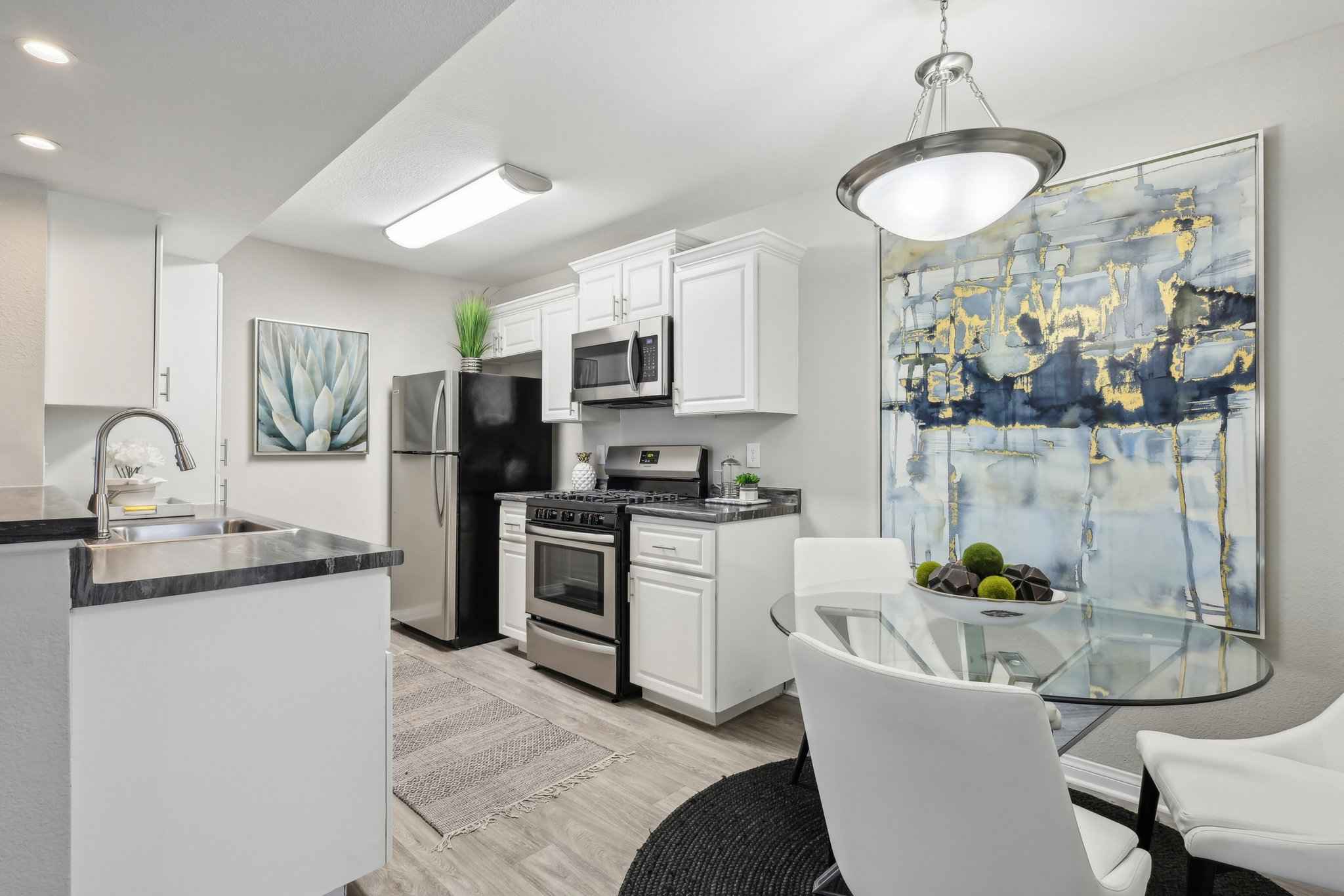 full view of kitchen with stainless steel appliances and counter space with storage cabinets and oven and refrigerator at Millennium East