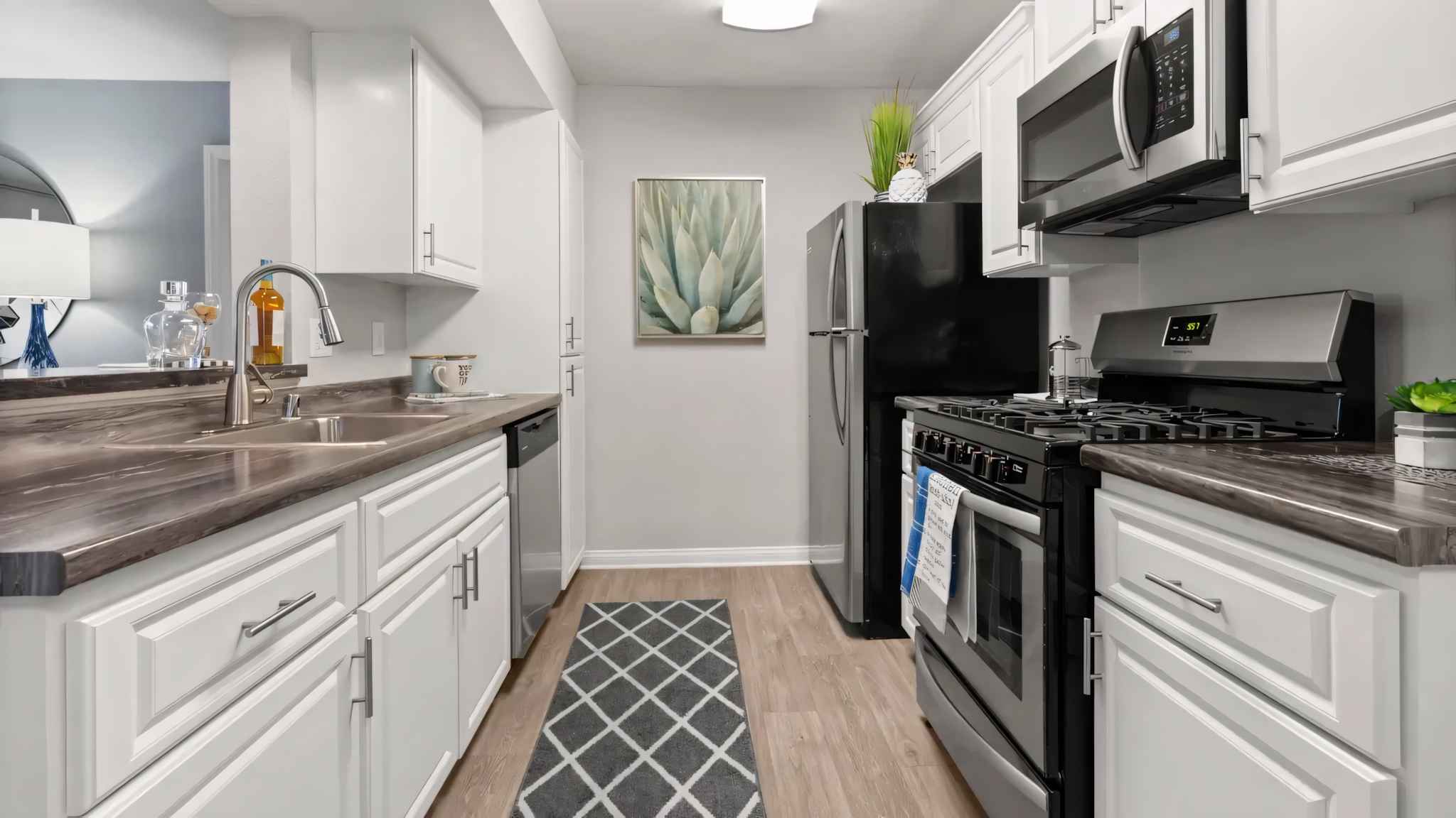 full view of kitchen with stainless steel appliances and counter space with storage cabinets at Millennium East