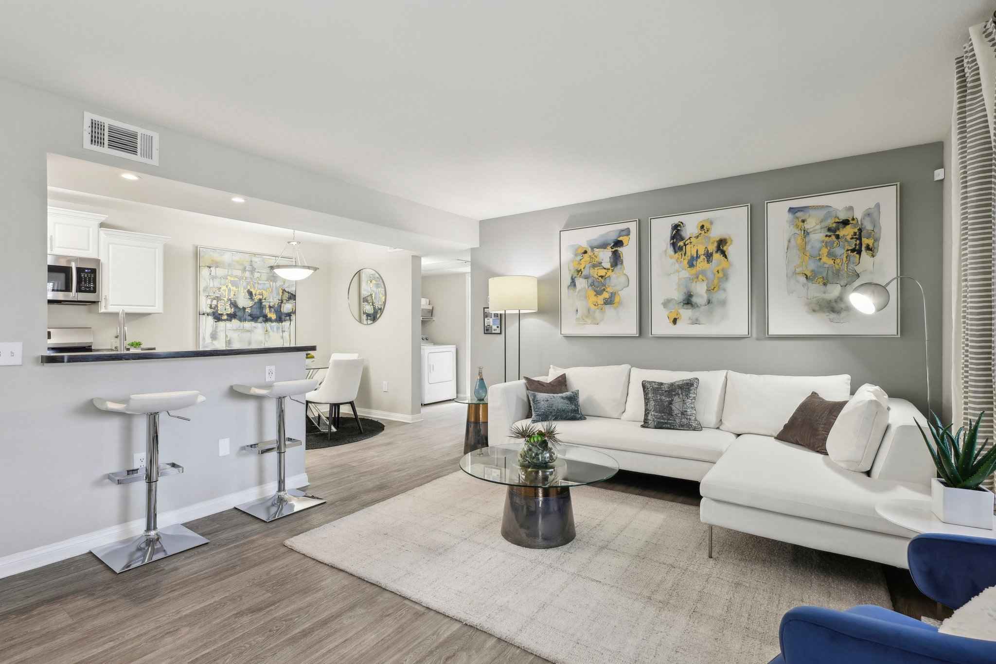 living room showing kitchen and hallway entrance at Millennium East