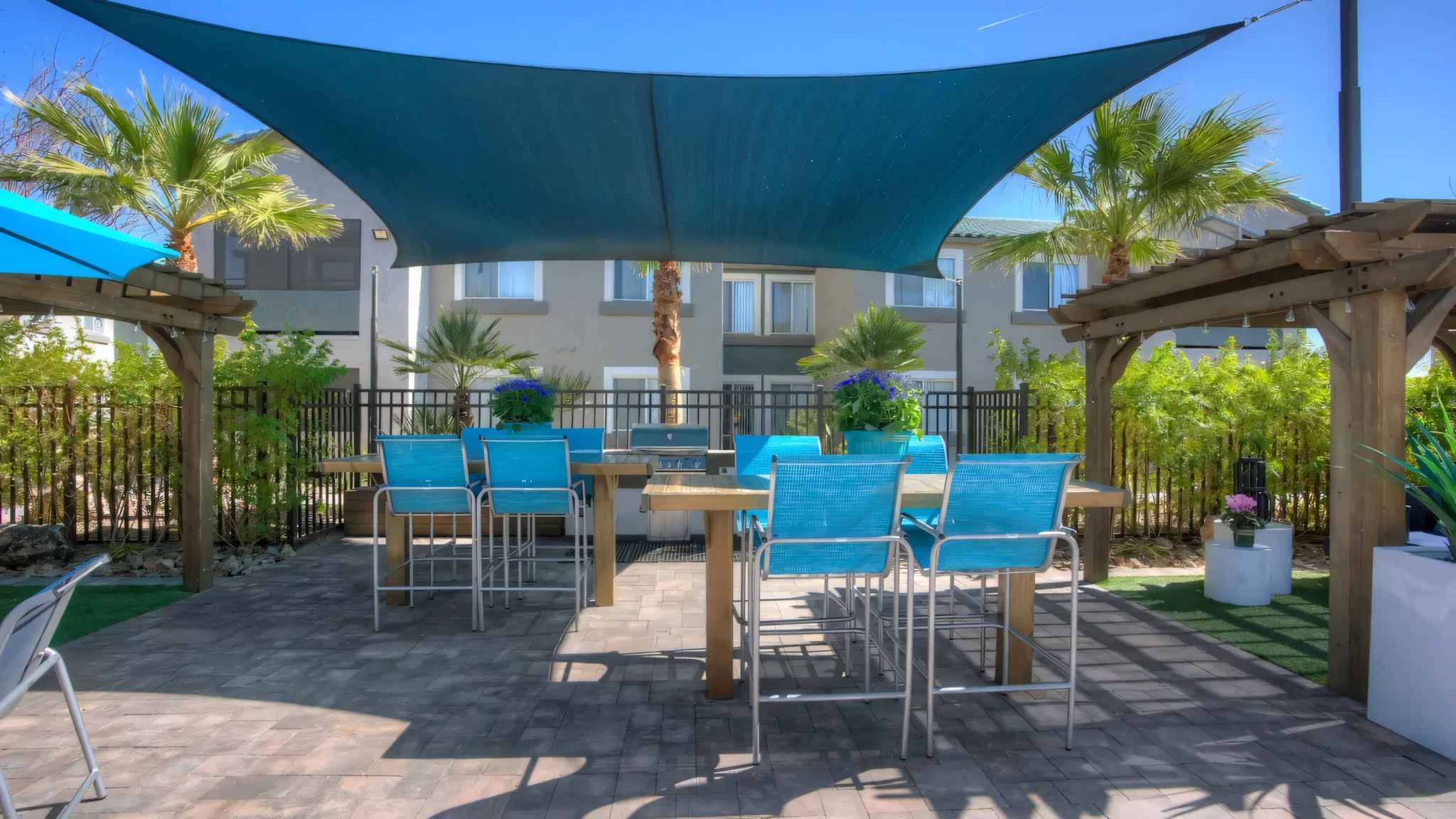 outdoor kitchen area with grill and table and chairs at Millennium East